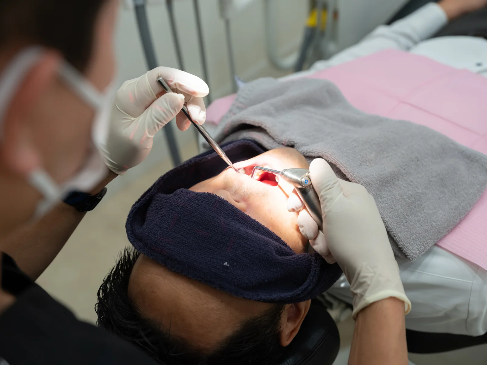 患者様の口腔内を確認しながら歯科治療を行う様子